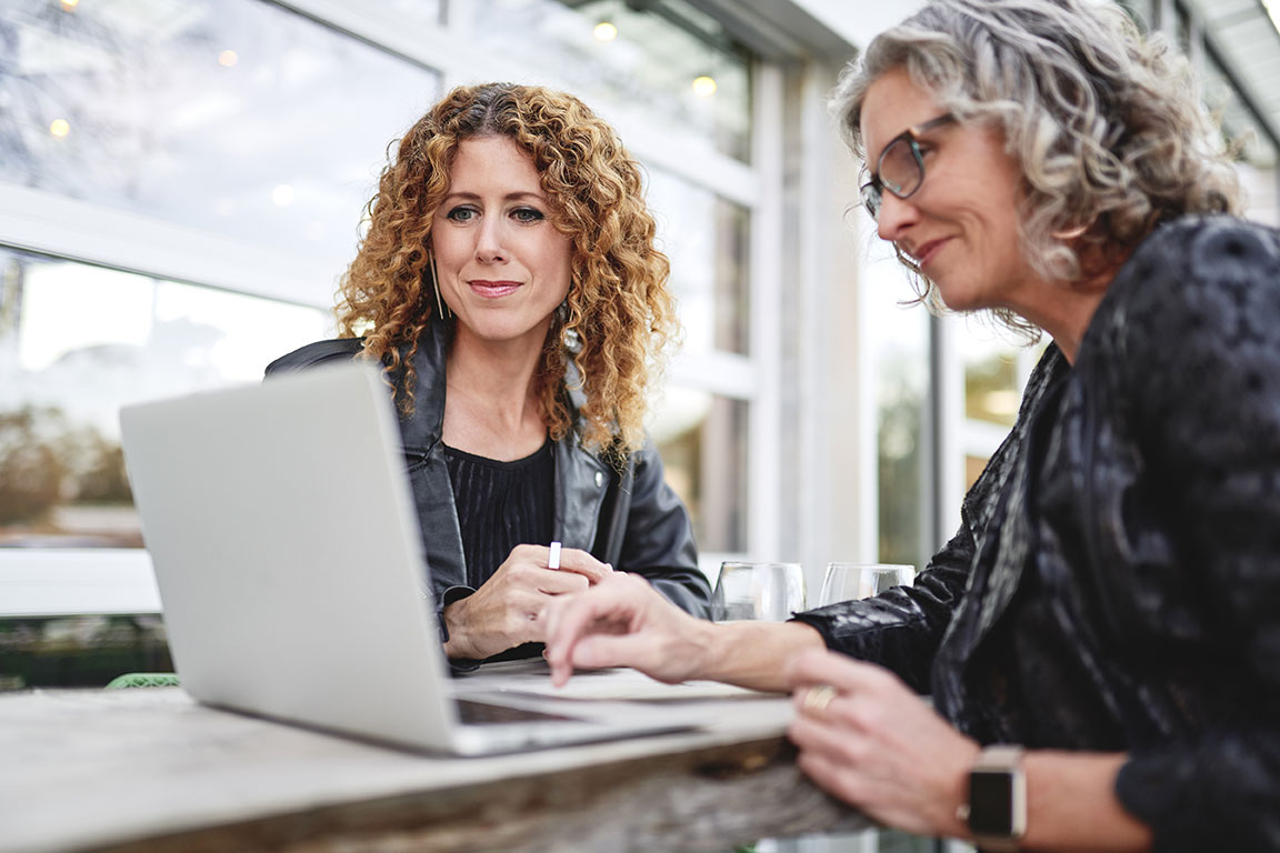 Two people working together looking at a laptop