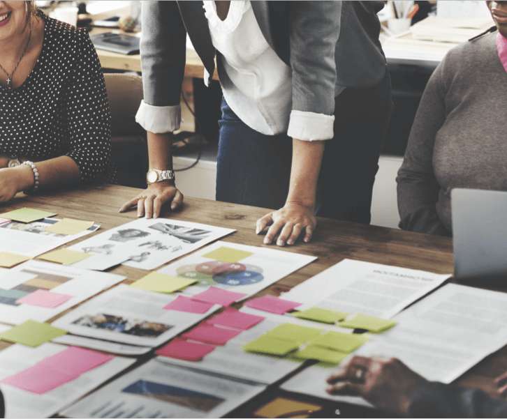 People looking at strategic documents on table in meeting setting